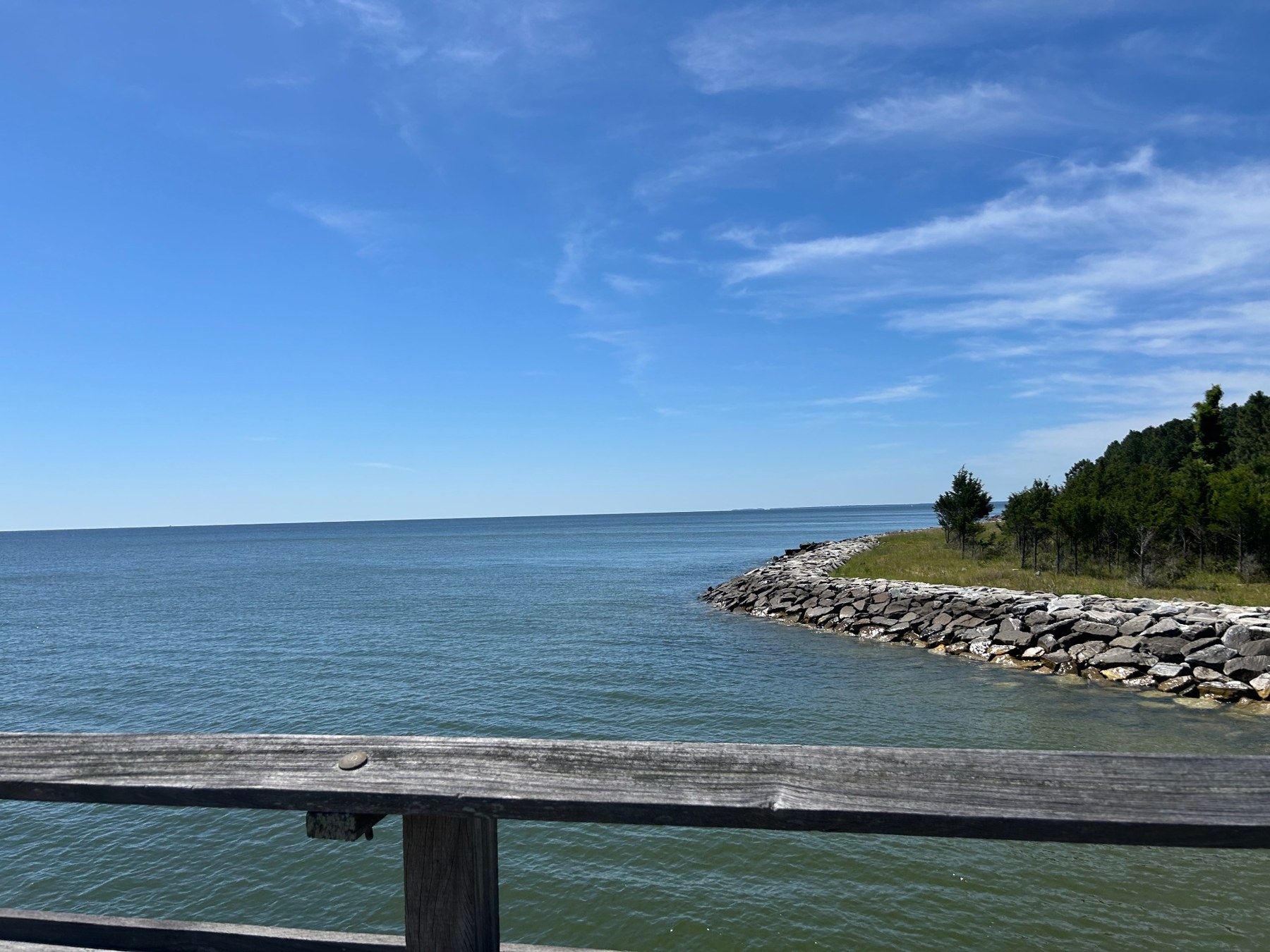 A rocky shoreline viewed from a wooden railing