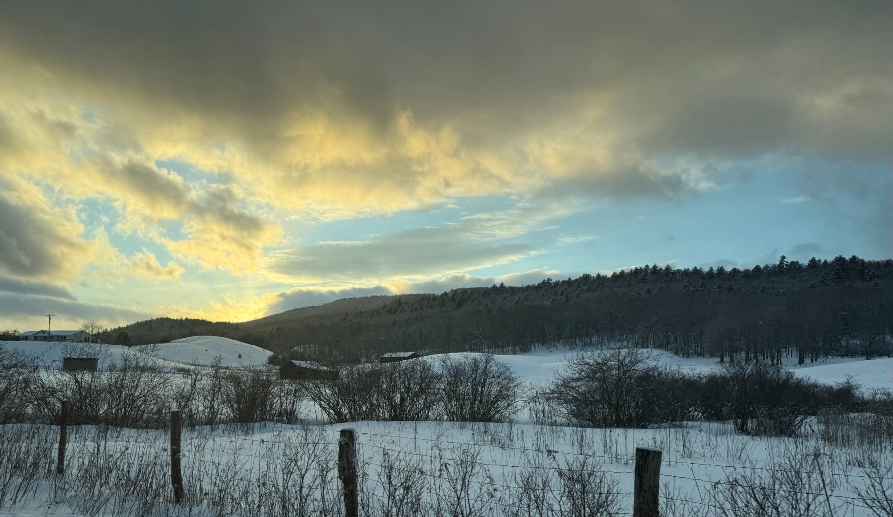 Snowy hills beneath a golden evening sky